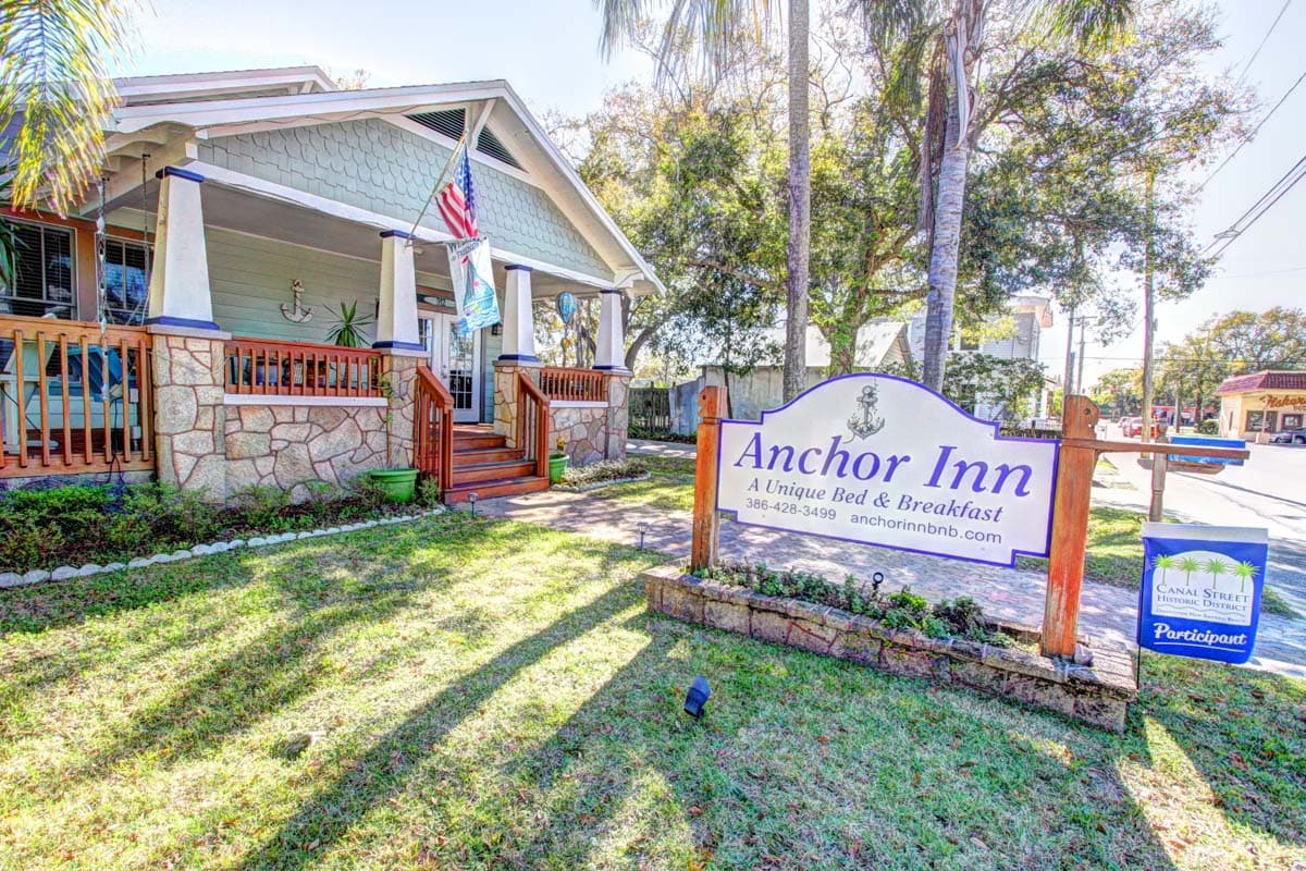 Exterior view of Anchor Inn Bed & Breakfast with signage and lush greenery.