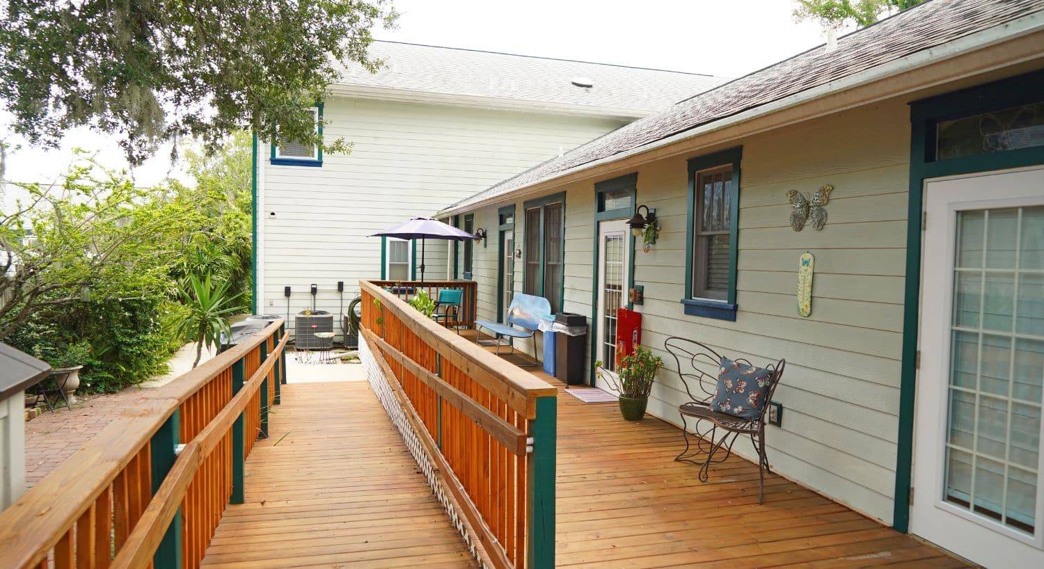 Outside deck of a spacious home with a long ramp and railing